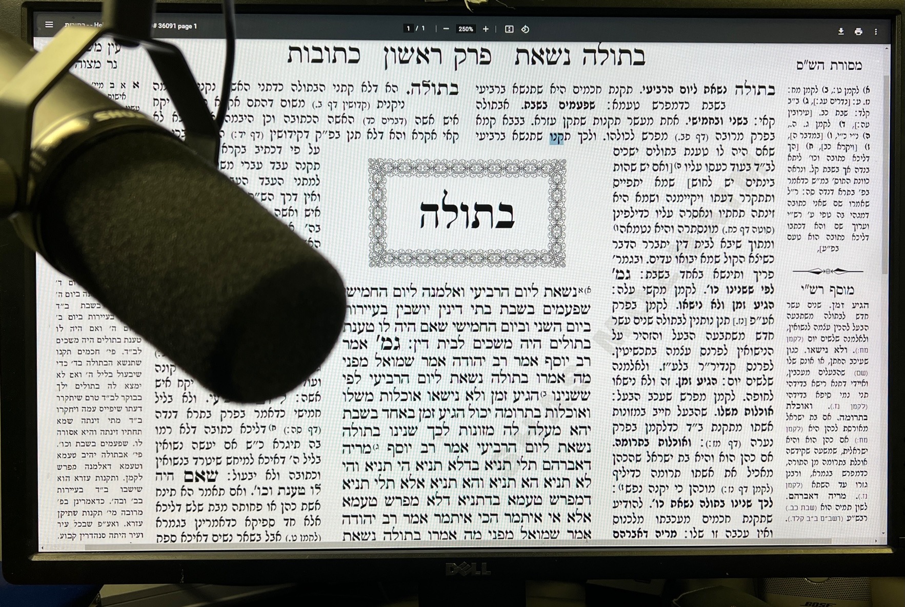 Gemara Kesuvos displayed behind a studio microphone